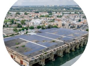 Toiture équipée de panneaux photovoltaïques sur la base sous-marine de Bordeaux, dans un environnement urbain.
